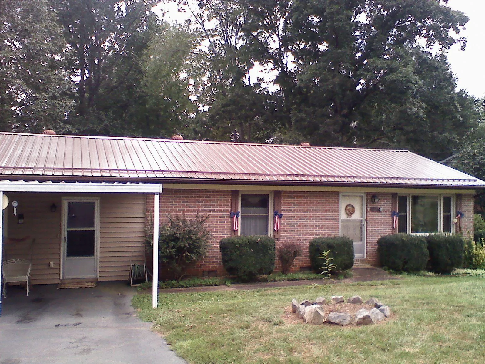 Bronze metal roof and carport on a brick ranch home — Roof Repair work by our crew in Ruston